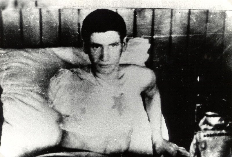A wounded Jewish fighter, with a yellow badge on his bandages, in a hospital in the Vilna ghetto.